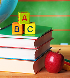 stack of school books with blocks and apple